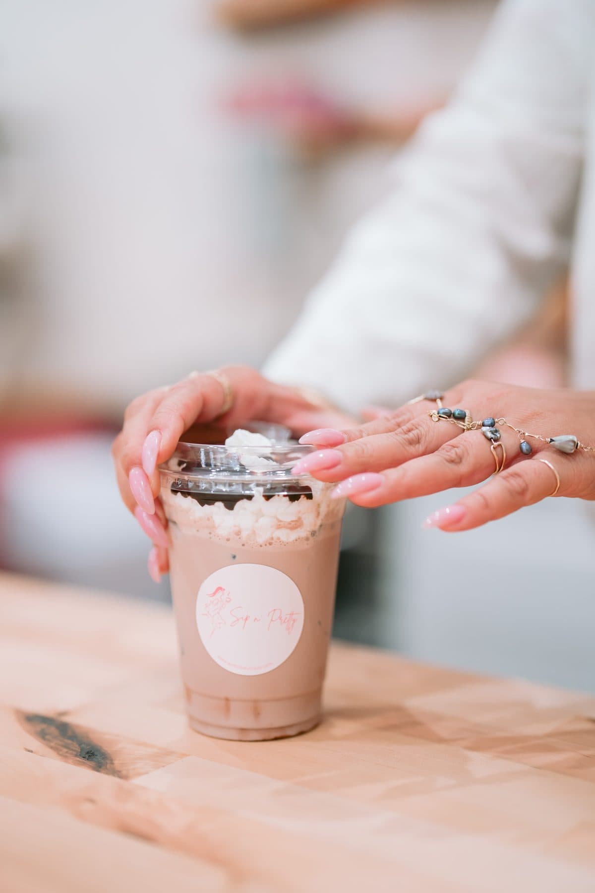 Vanilla cold foam being poured over an iced white mocha at the Sip n' Pretty bar.