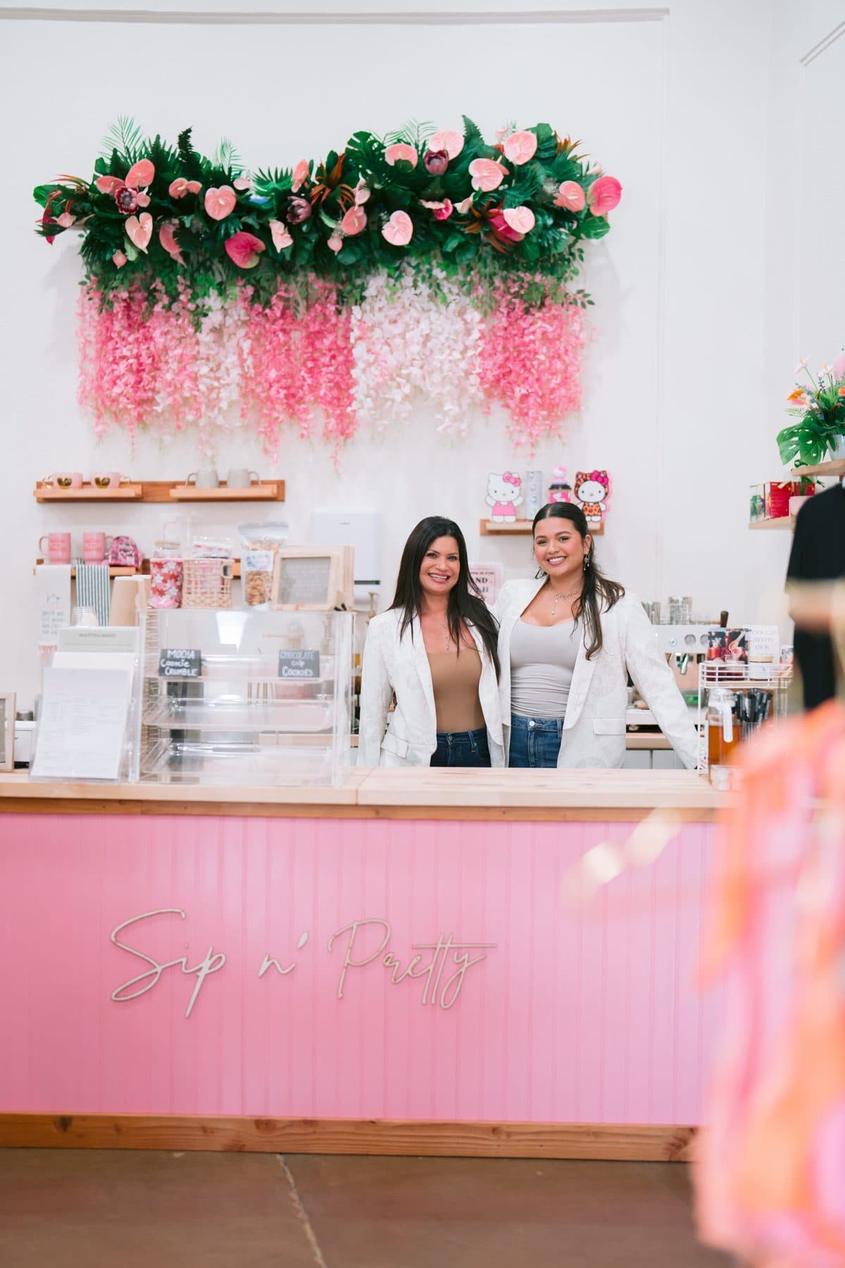 The mother-and-daughter team behind the pink scalloped Sip n' Pretty counter in Hilo, fresh florals overhead.